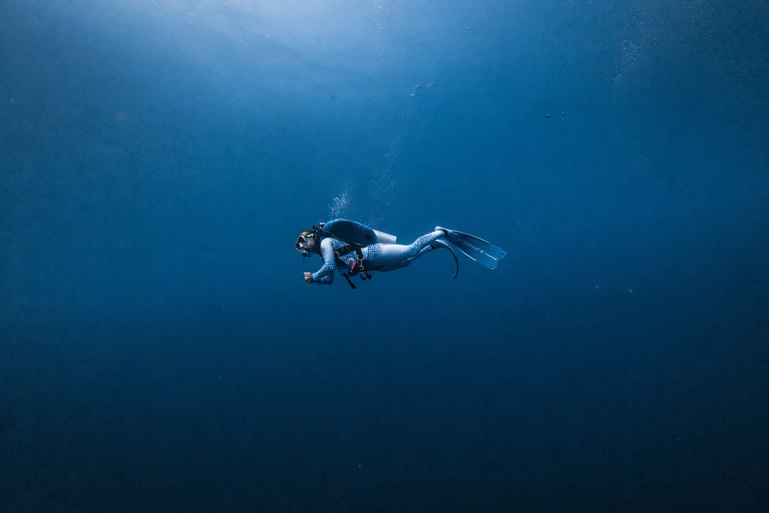 A diver suspended in the deep blue of South Ari Atoll.